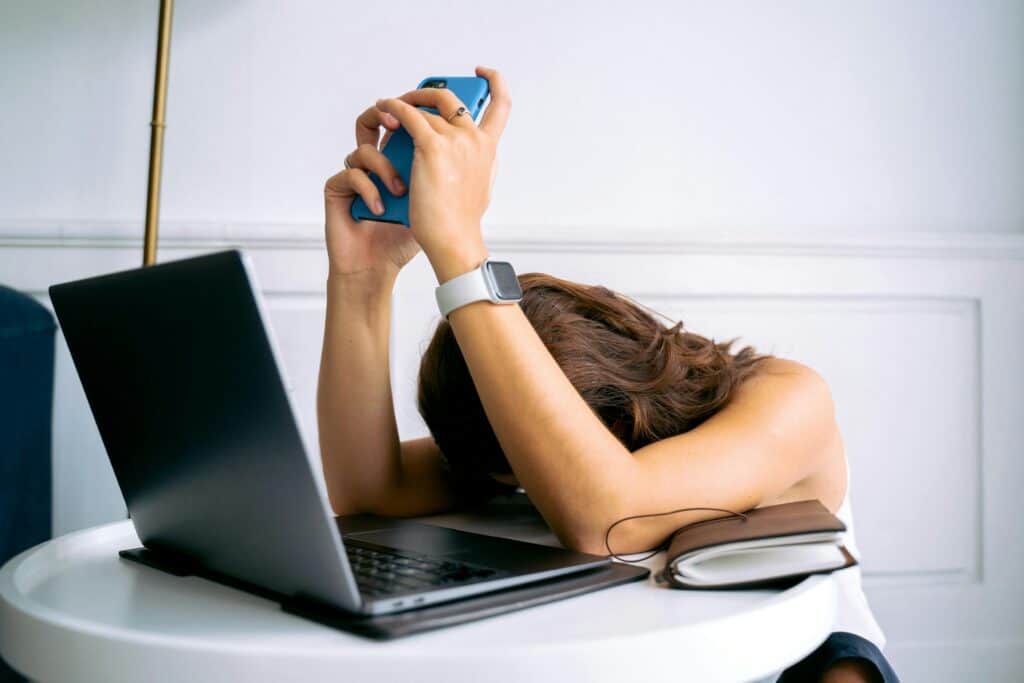 A person looking overwhelmed while researching the best soil for growing cannabis in pots on their laptop.