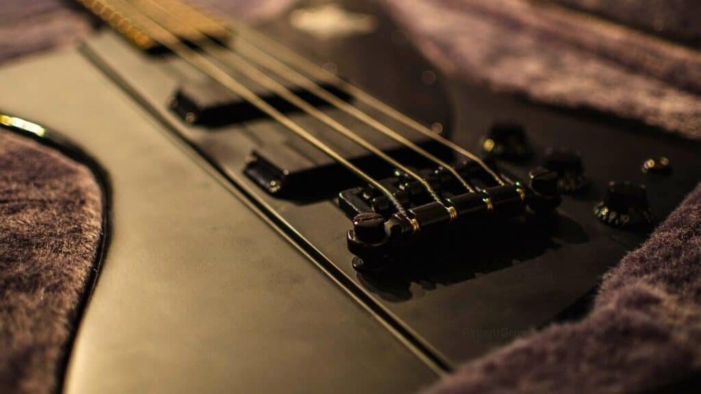 A close-up of a black bass guitar, used as an analogy for how terpenes and other compounds contribute to the cannabis entourage effect.